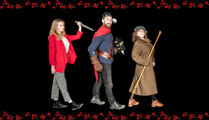 the tales of adventure cast stood in a line marching towards the right. A woman with long blonde hair in a red blazer and check trousers, a man in a red cape with a medieval helmet on and brown leather sword belt and a woman wearing a flat cap and brown trench coat holding a staff.