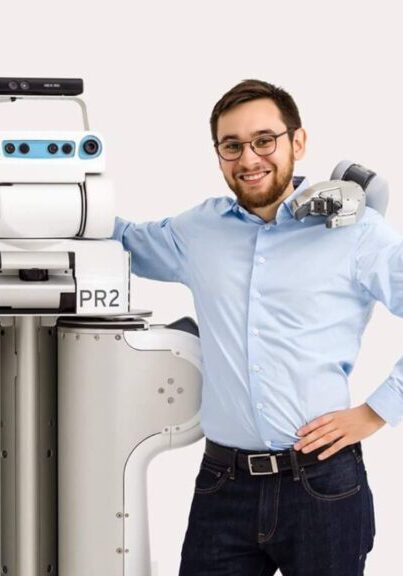 Tom williams stands with a robot