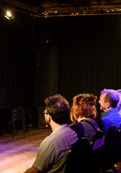 Imogen Palmer stands on stage teaching improv